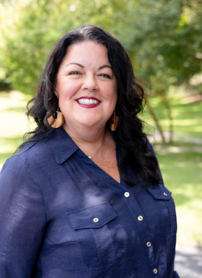 Portrait of Lacy Basford smiling outdoors in a blue shirt.