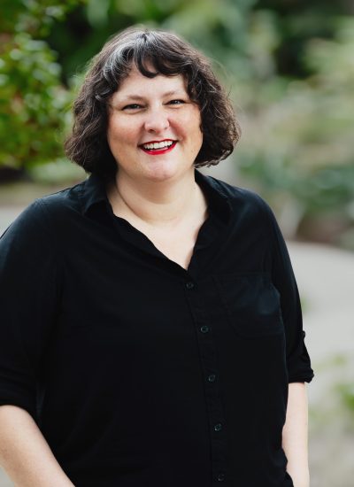Erica Littauer smiling outdoors in a black shirt.