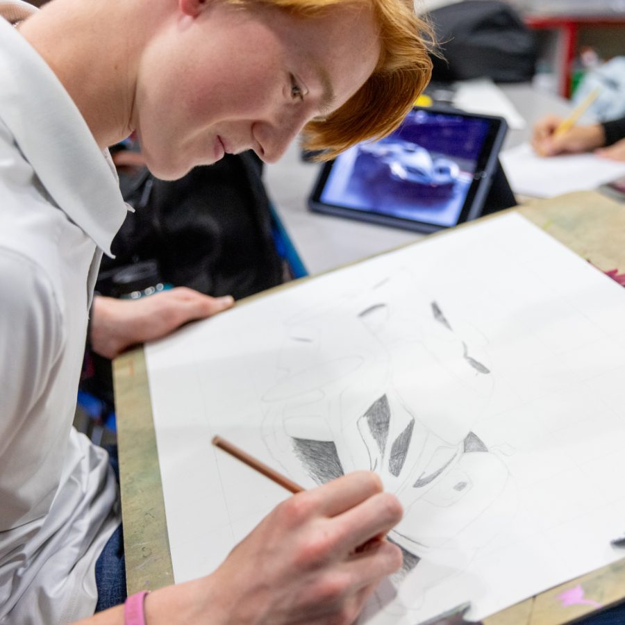 A high school student develops his ability to shade his art in art class.