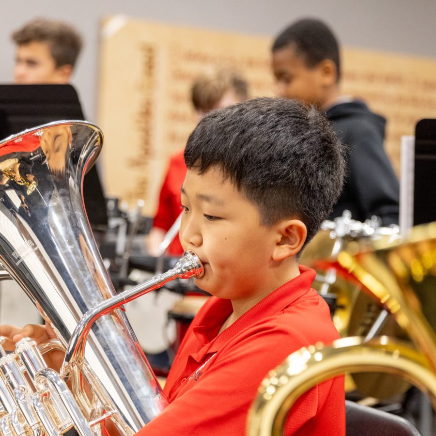 An Elementary age boy playing a tuba